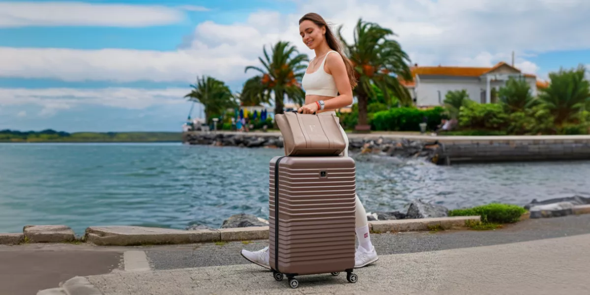 junge Frau, die mit ihrem Urlaubskoffer spazieren geht