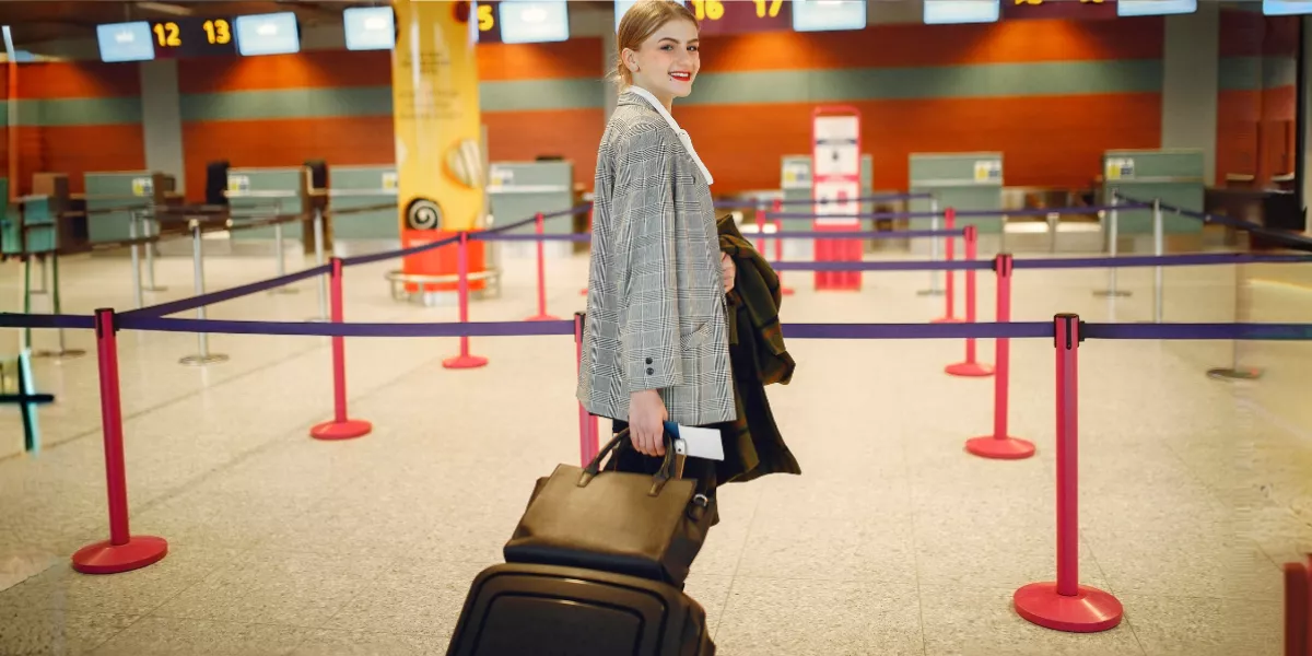 Zufriedener Passagier mit Gepäck am Check-in-Schalter