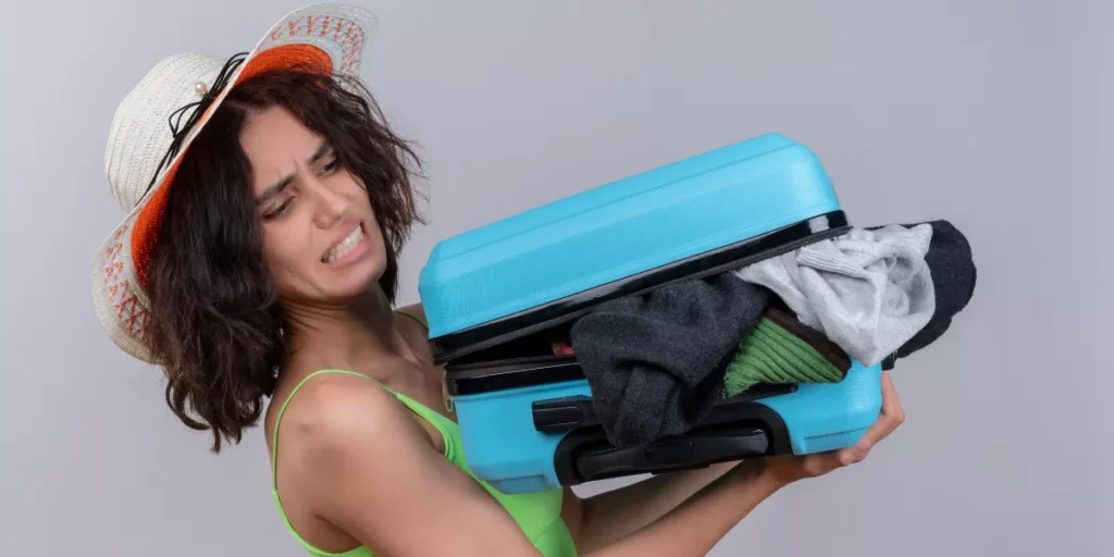 Frau mit schwerem Koffer vor der Reise
