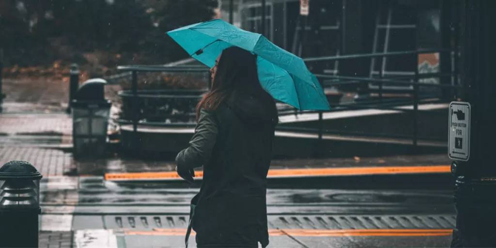 Frau mit Regenschirm in der Stadt an einem regnerischen Tag